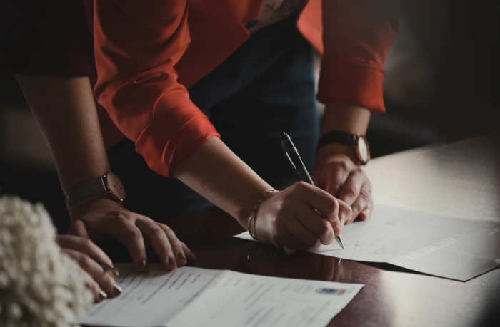 two people signing a document